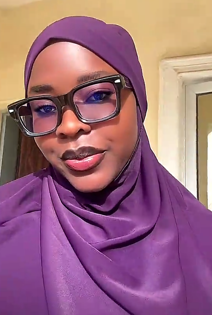 Close-up of Saida in a purple hijab, glasses and hi-vis vest on site